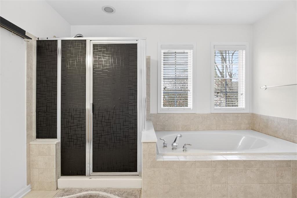 3210 Warbler Way Cumming, GA 30041 - Photo 40 of 45 a bathroom with a bathtub and a shower