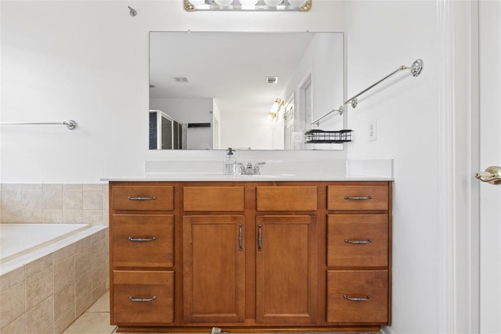 3210 Warbler Way Cumming, GA 30041 - Photo 43 of 45 a bathroom with a sink a vanity and a mirror