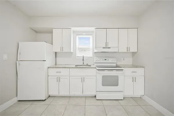 a kitchen with cabinets appliances a sink and a stove