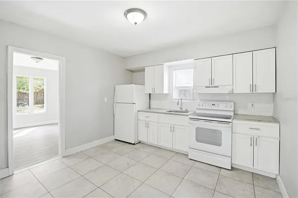 a kitchen with white cabinets and white appliances