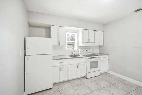 a kitchen with white cabinets and white appliances