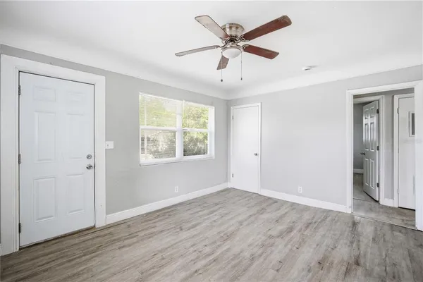 an empty room with wooden floor and windows