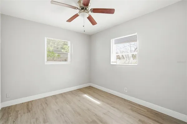 an empty room with a window and a fan