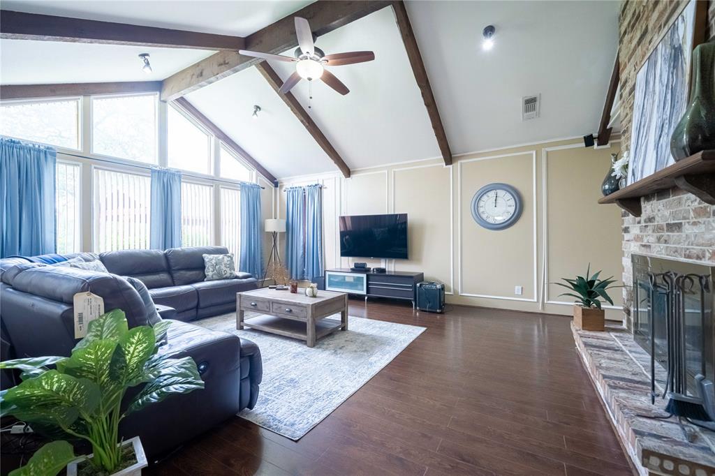 919 Green Hills Road Duncanville, TX 75137 - Photo 14 of 37 Living room with a ceiling fan, a decorative wall, wood finished floors, and a brick fireplace
