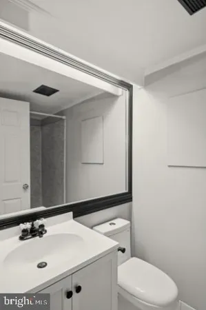 a bathroom with a sink a toilet and mirror