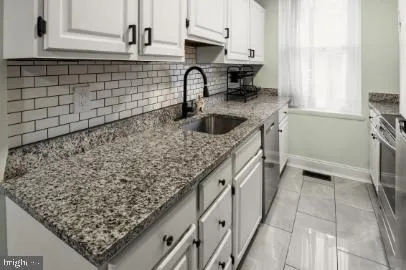 a kitchen with a sink a stove and cabinets