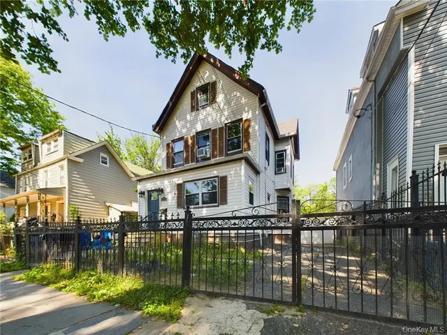 a front view of a house with lake view and a fountain