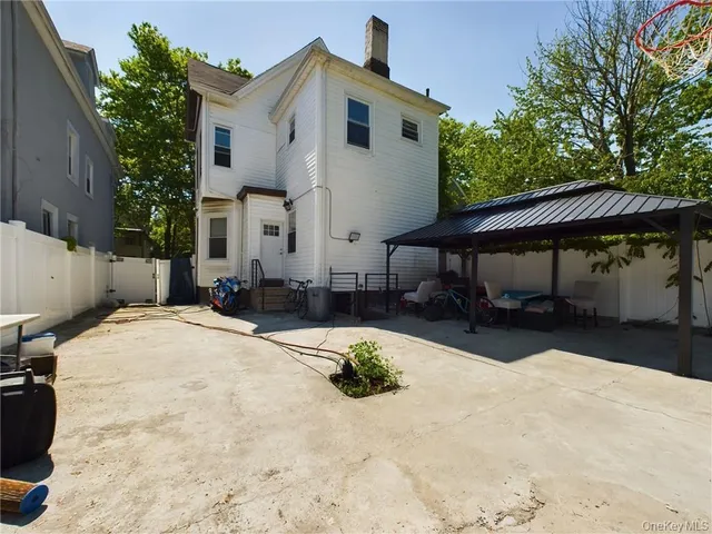 a view of a white house with a yard and sitting area