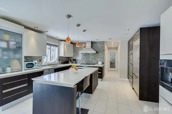 a kitchen with a sink a center island cabinets and appliances