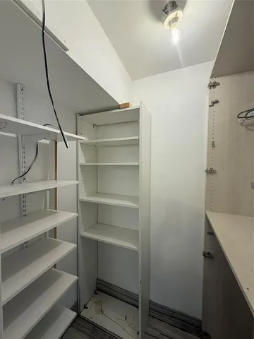 a view of walk in closet with empty racks