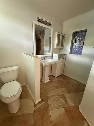 a bathroom with a toilet sink and mirror