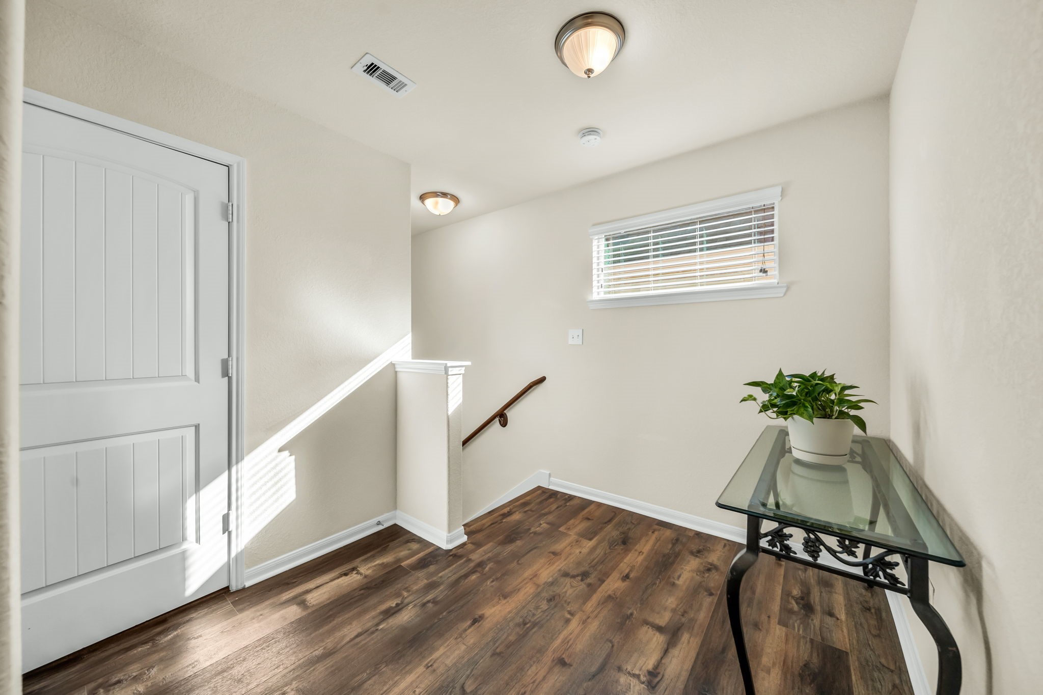 14212 Portrait Court Houston, TX 77045 - Photo 18 of 27 Bright and inviting upstairs landing with elegant wood flooring and modern lighting.