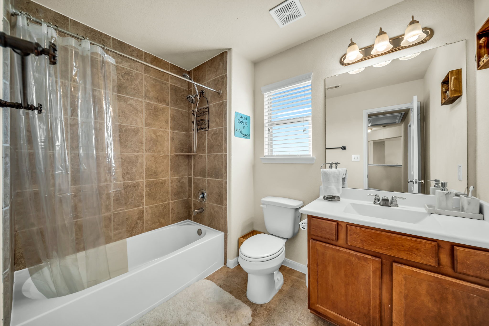 14212 Portrait Court Houston, TX 77045 - Photo 20 of 27 Modern secondary bathroom with elegant tile, bright lighting, and a convenient shower-tub combo.