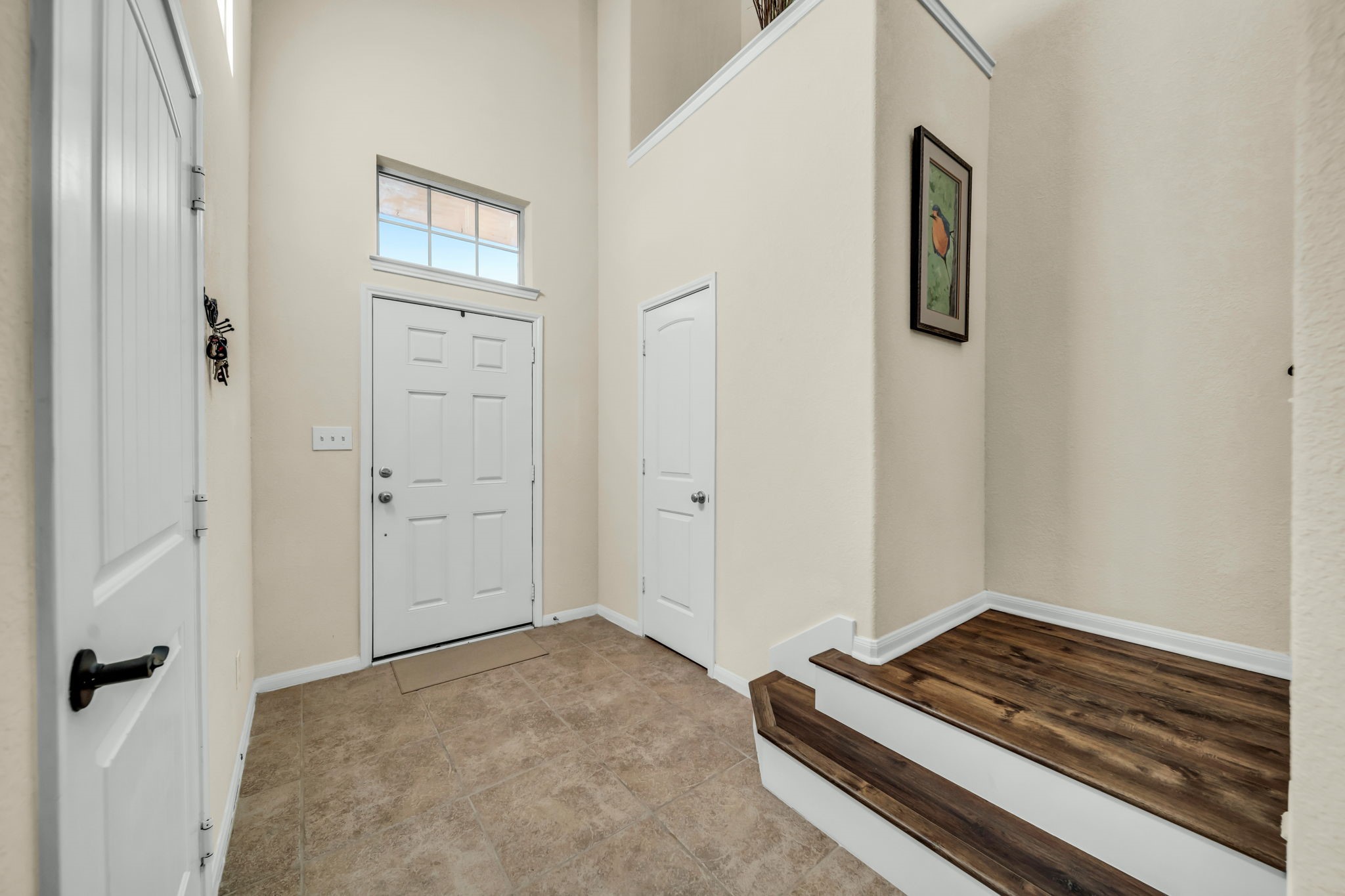 14212 Portrait Court Houston, TX 77045 - Photo 2 of 27 Welcome home to a bright, inviting entrance with high ceilings, elegant tile flooring, and warm, luxurious wood flooring.