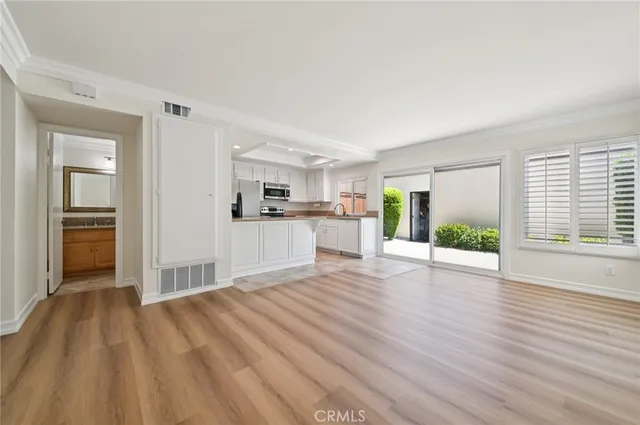 a view of empty room with wooden floor and window