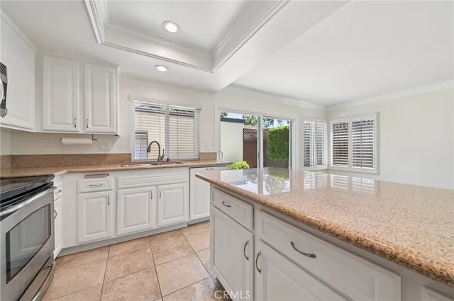 a kitchen with granite countertop white cabinets and white appliances