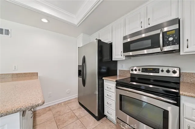a kitchen with stainless steel appliances a stove microwave and sink
