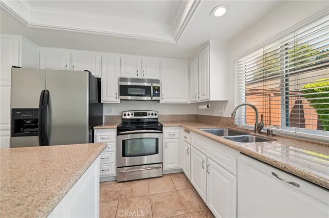 a kitchen with kitchen island granite countertop a sink stainless steel appliances and cabinets