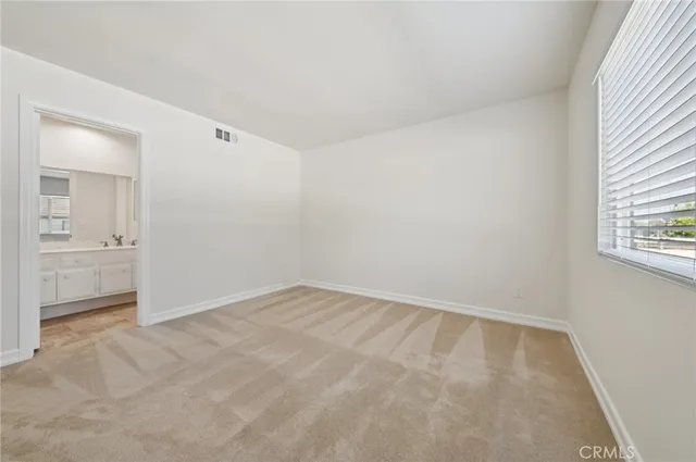 an empty room with a bathroom and a sink