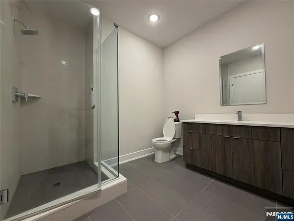 a spacious bathroom with a double vanity sink toilet and shower