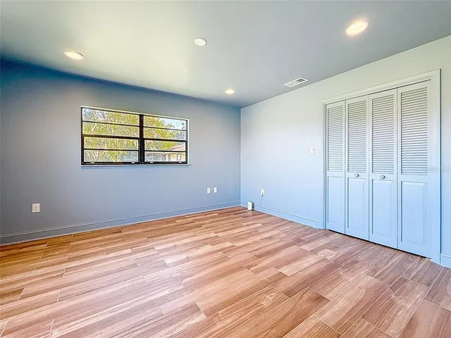 a bedroom with a bed and painting on the wall