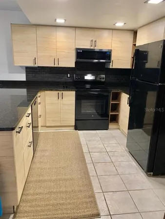 a view of a living room with a stove and a refrigerator