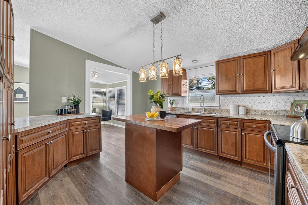 449 Big Salty Lane Springtown, TX 76082 - Photo 7 of 25 Kitchen featuring wood-finish flooring, wood cabinetry with brushed nickel hardware, light-toned countertops, and a decorative tile backsplash