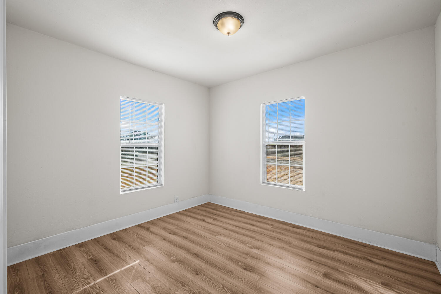 620 South 11th Street Slaton, TX 79364 - Photo 17 of 22 an empty room with wooden floor and windows