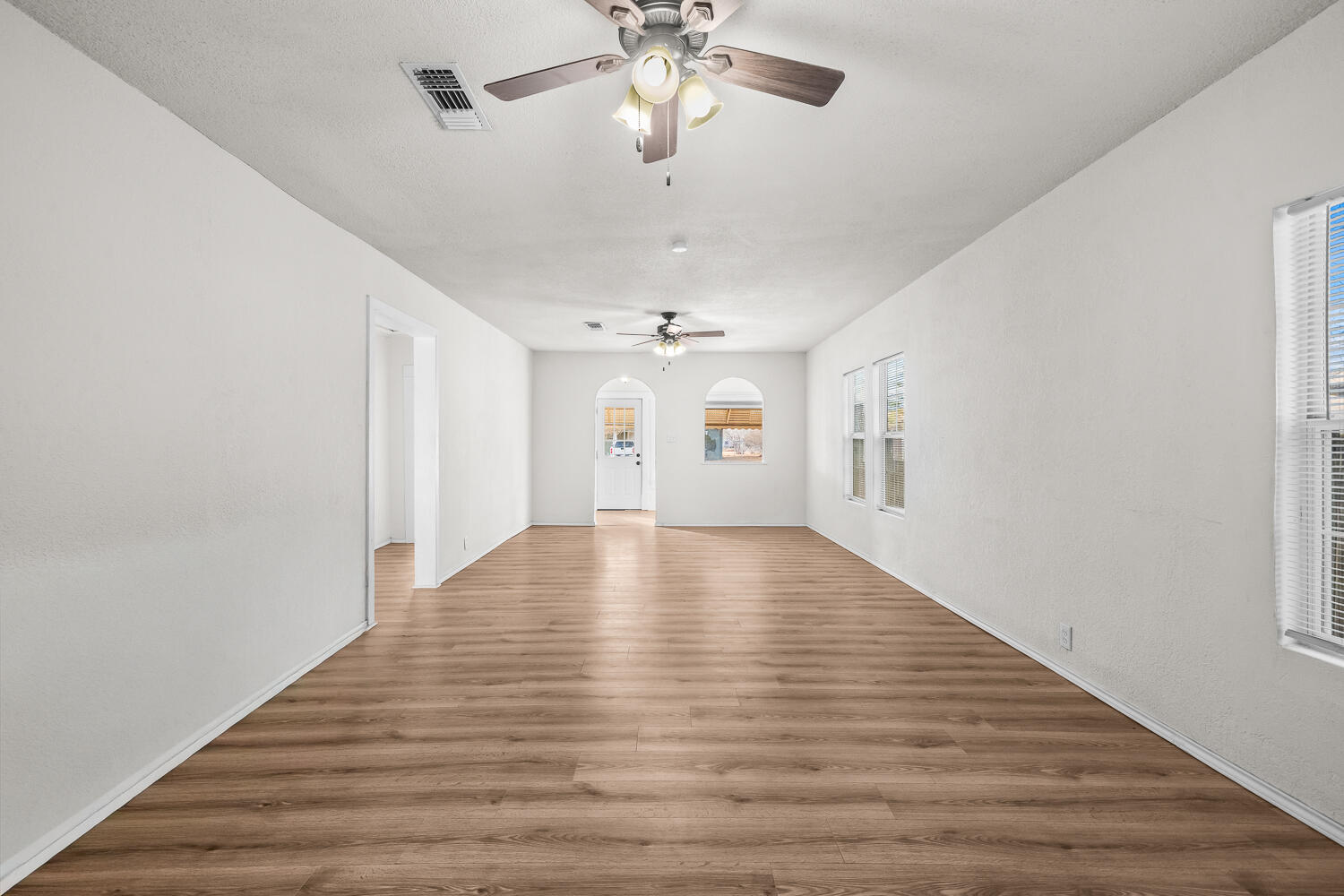 620 South 11th Street Slaton, TX 79364 - Photo 7 of 22 wooden floor in an empty room with a window
