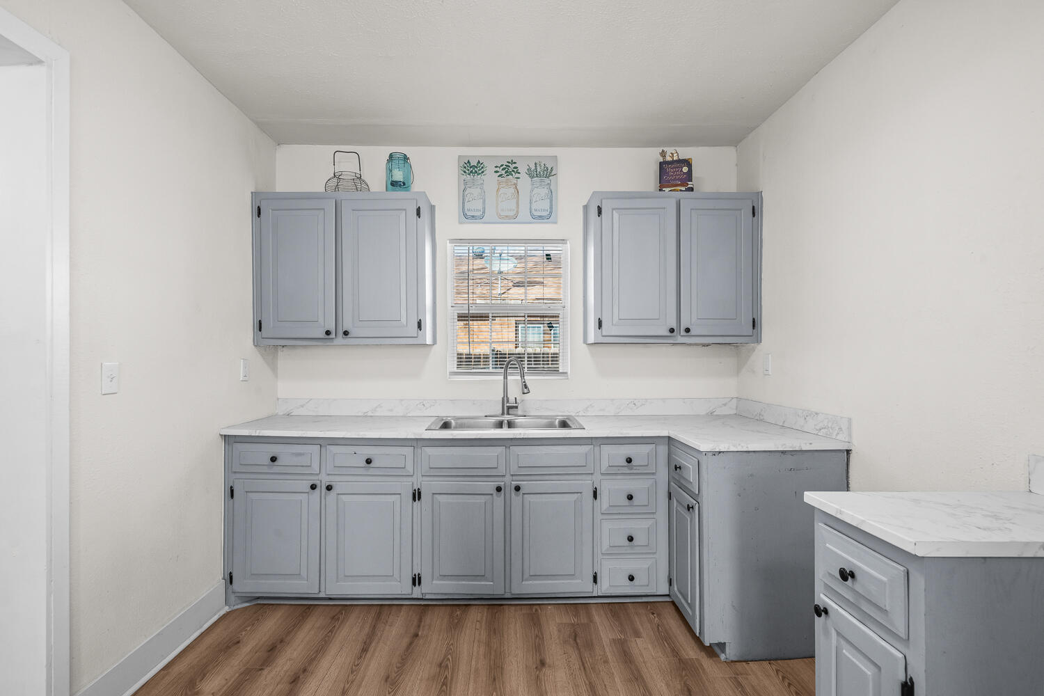 620 South 11th Street Slaton, TX 79364 - Photo 10 of 22 a kitchen with a sink cabinets and wooden floor