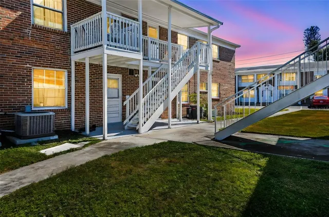 a view of an house with backyard and a tree