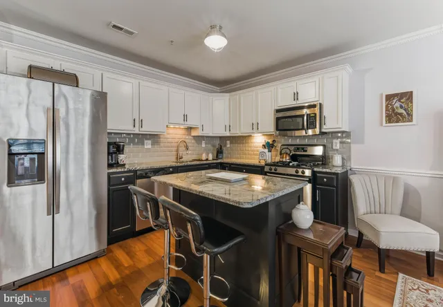 a kitchen with stainless steel appliances a stove a sink refrigerator and a stove