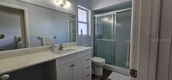 a bathroom with a granite countertop sink toilet and shower