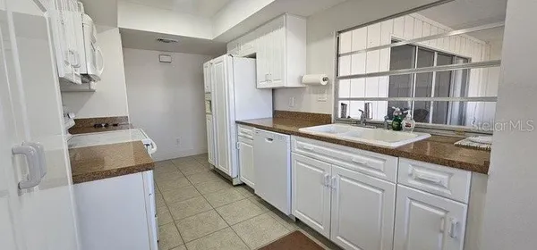 a kitchen with granite countertop a sink stainless steel appliances and cabinets