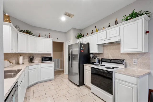 a kitchen with cabinets stainless steel appliances and sink