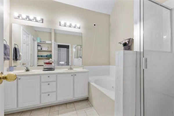 a bathroom with a tub a sink and mirror
