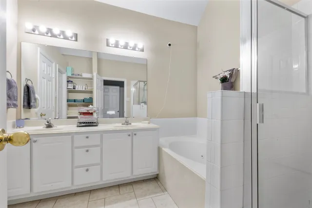 a bathroom with a tub a sink and mirror