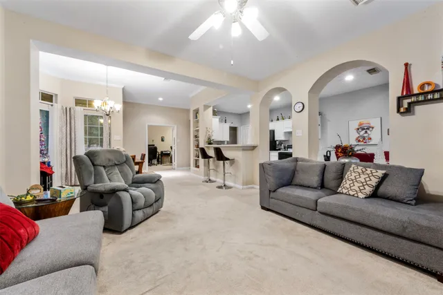 a living room with furniture and a large mirror with potted plants