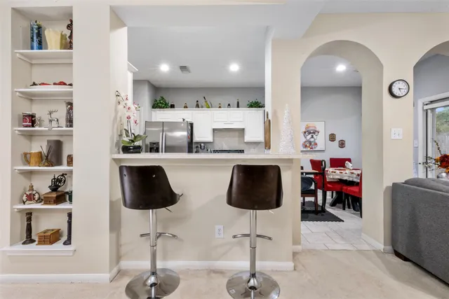 a kitchen with stainless steel appliances kitchen island granite countertop a refrigerator and cabinets