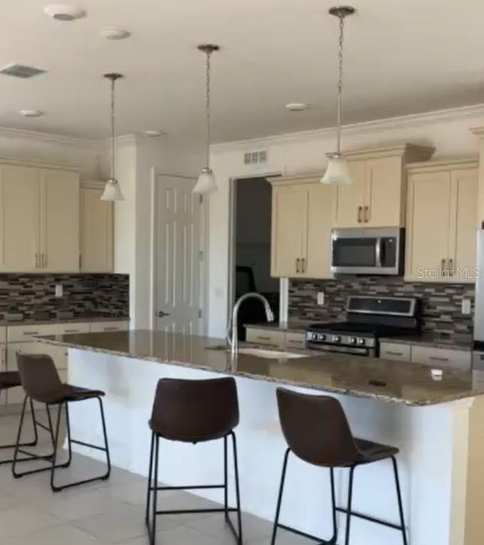 10584 Southwest 91st Street Road Ocala, FL 34481 - Photo 11 of 20 a kitchen with stainless steel appliances granite countertop a stove a sink a refrigerator a dining table and chairs with wooden floor
