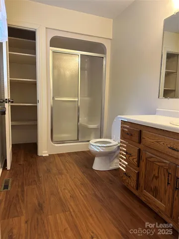 a bathroom with a sink a toilet a window and shower