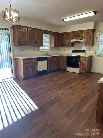 a kitchen with stainless steel appliances wooden floors and wooden cabinets