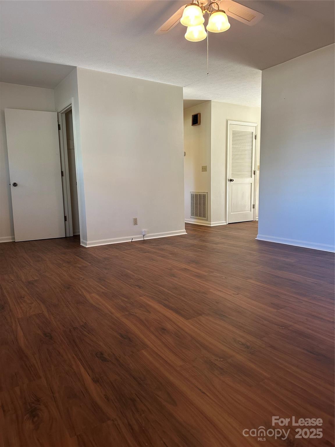 Undisclosed Address Hendersonville, NC 28792 - Photo 6 of 19 an empty room with wooden floor and chandelier fan