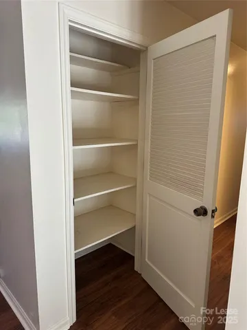 a view of walk in closet with empty racks
