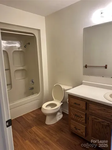 a bathroom with a granite countertop toilet a sink and a mirror