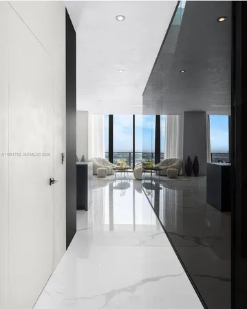 a large white kitchen with a large window and refrigerator