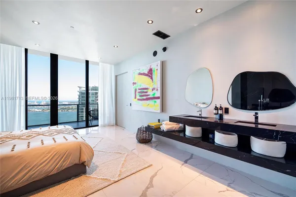 a bedroom with a bed and a large window