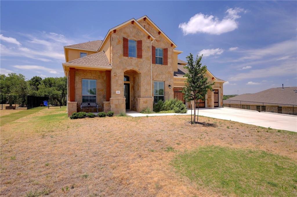 168 Raton Pass Dripping Springs, TX 78620 - Photo 3 of 20 Stone veneer exterior with red window shutters
