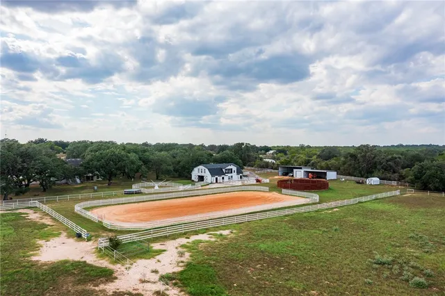 a view of a swimming pool with lawn chairs and couches chairs