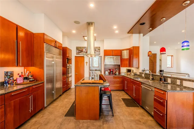 a large kitchen with stainless steel appliances kitchen island granite countertop a sink and cabinets